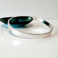 Silver bracelet  resting on a green bowl