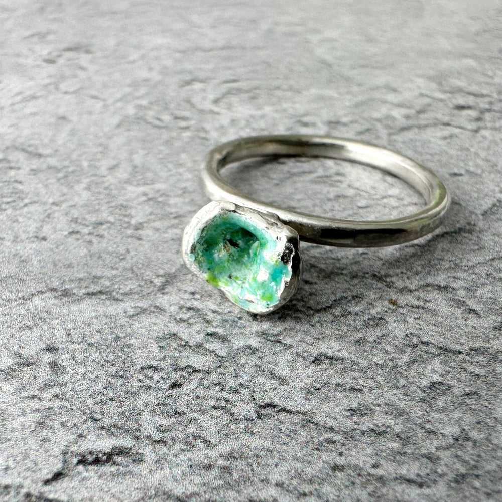 Handmade molten enamel silver ring with organic, irregular silver band and rough green enamel setting, photographed against a plain background, UK size P.