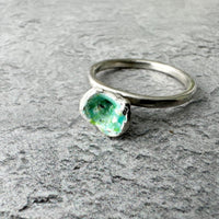 Handmade molten enamel silver ring with organic, irregular silver band and rough green enamel setting, photographed against a plain background, UK size P.