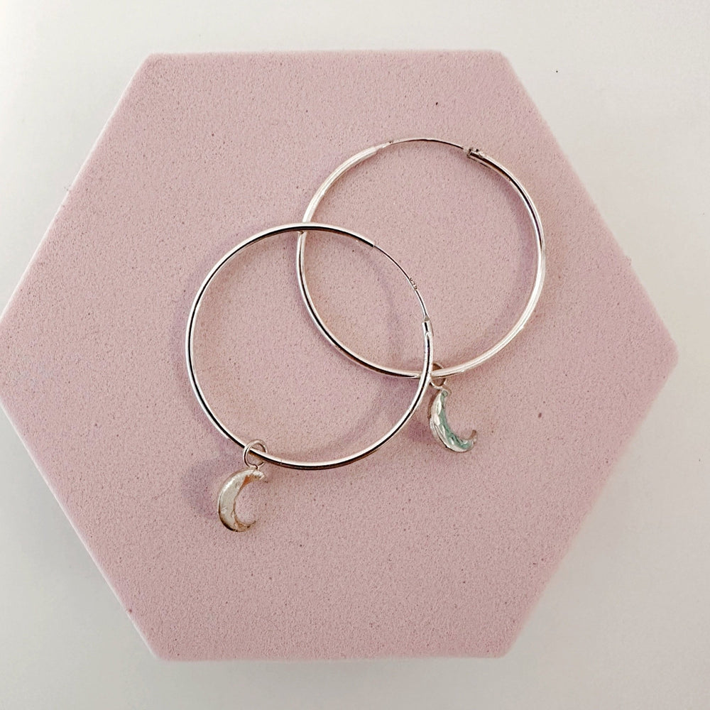 Close up of silver moon charms on 30mm sterling silver hoops