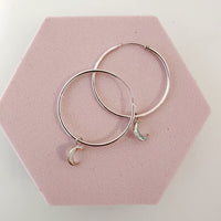 Close up of silver moon charms on 30mm sterling silver hoops