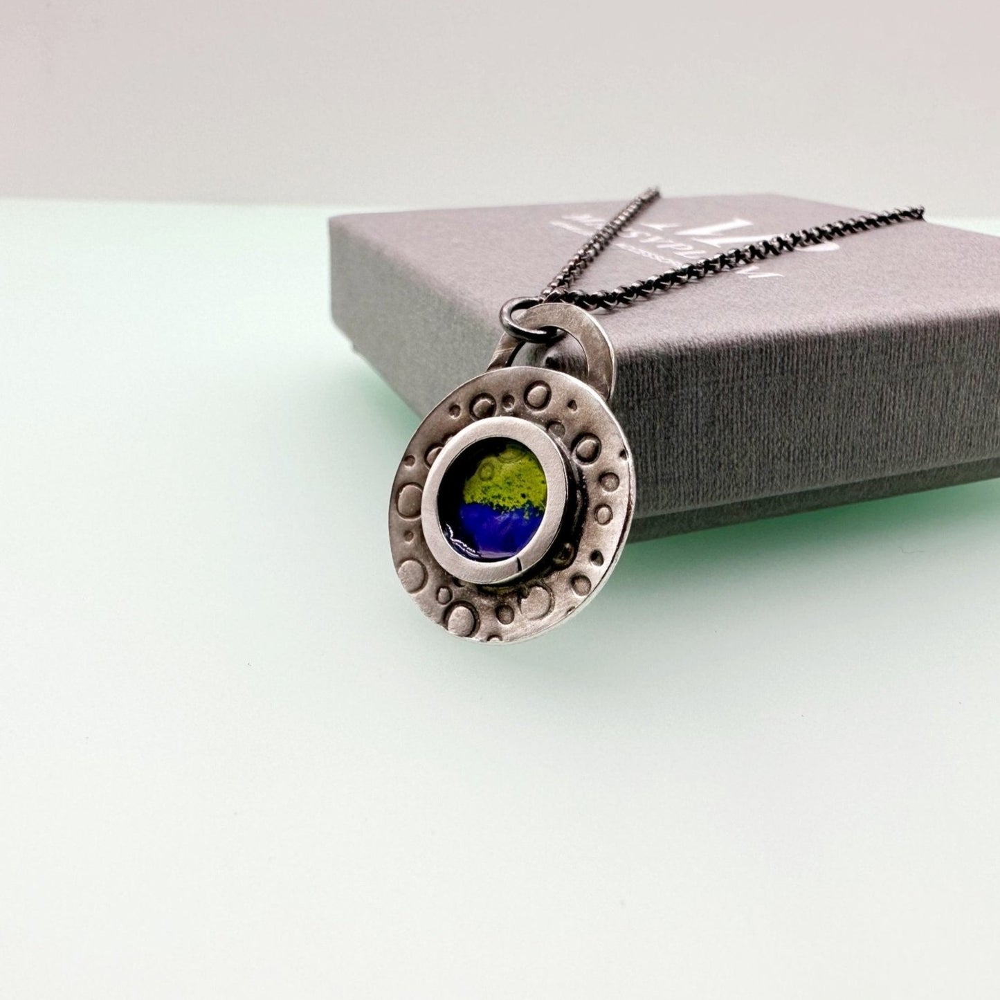 Round handstamped silver pendant with blue and green enamel