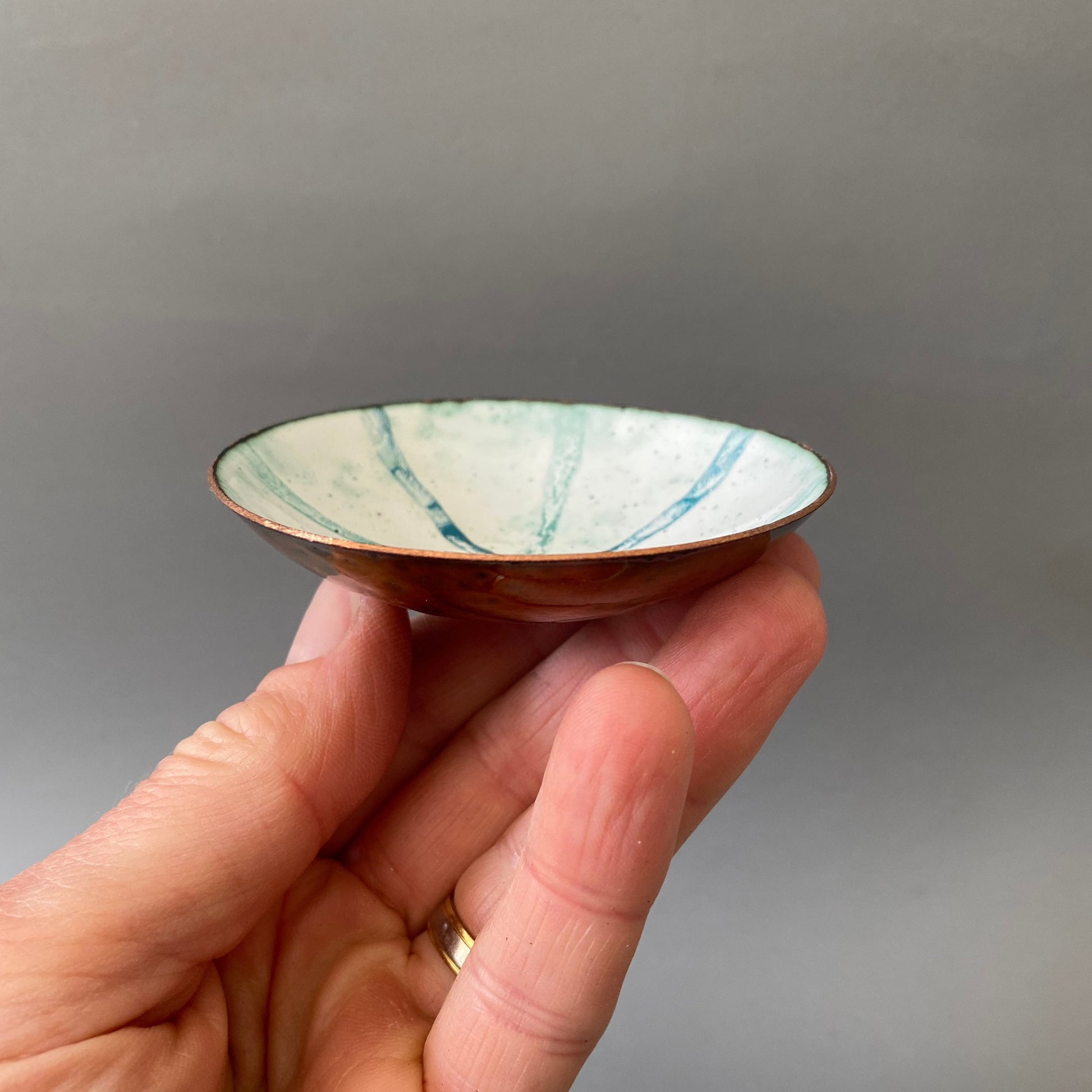 fingers holding enamel ring bowl in white and blue stripes - MaisyPlum